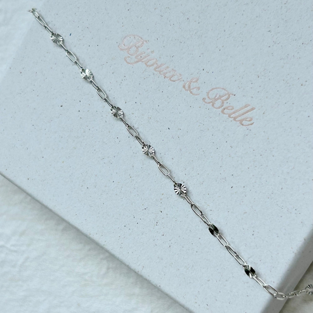 Sterling silver starburst bracelet on a white textured box with 'Bijoux& Belle' branding.