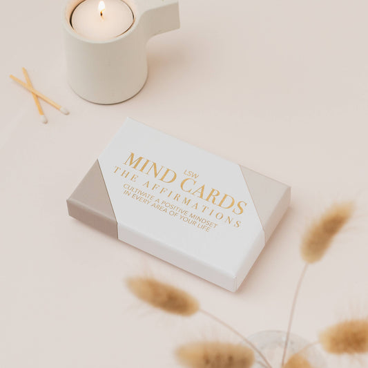 Box of Affirmation 'Mind Cards' with a candle and matches on a light surface