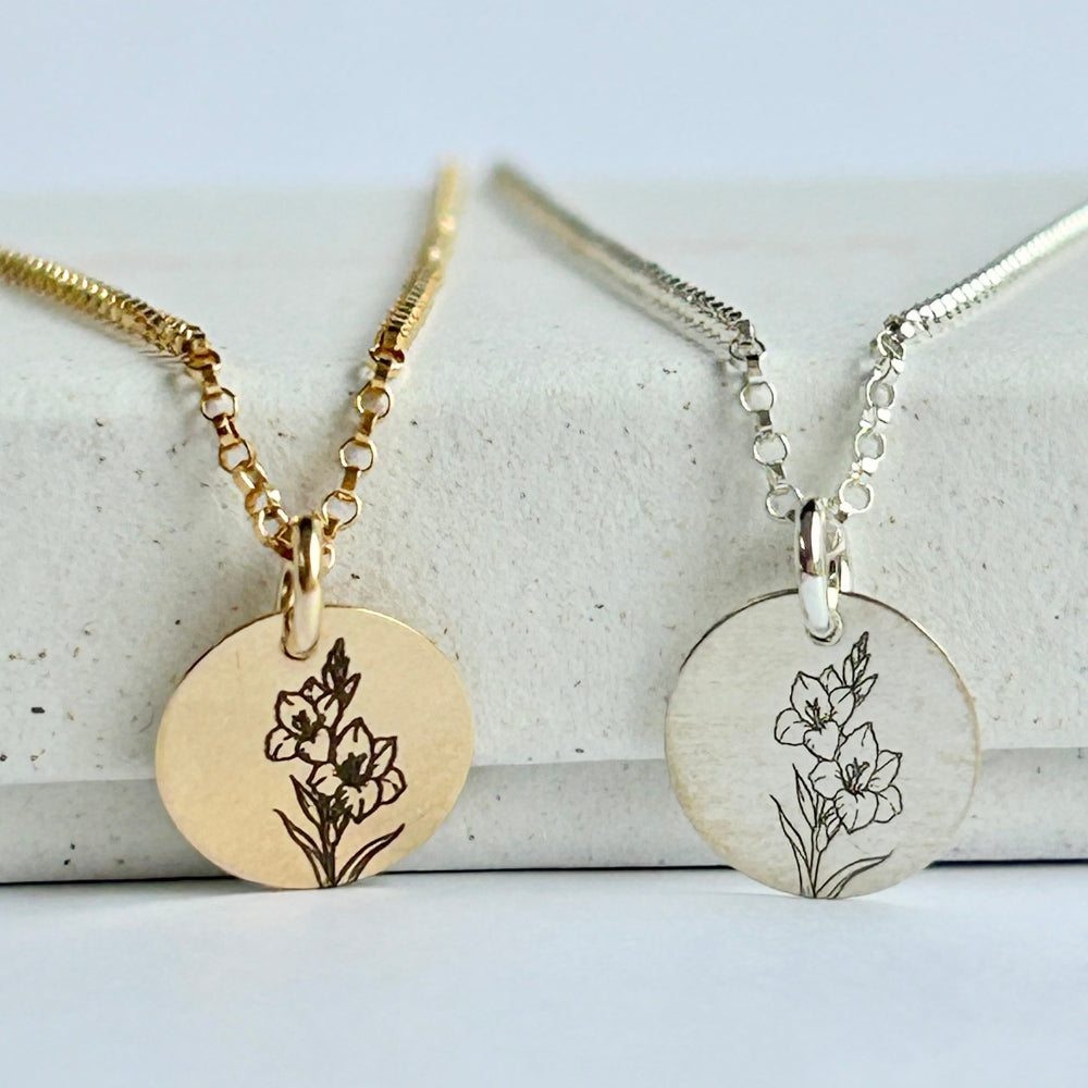 August birth flower necklaces in silver and gold, resting on a white box