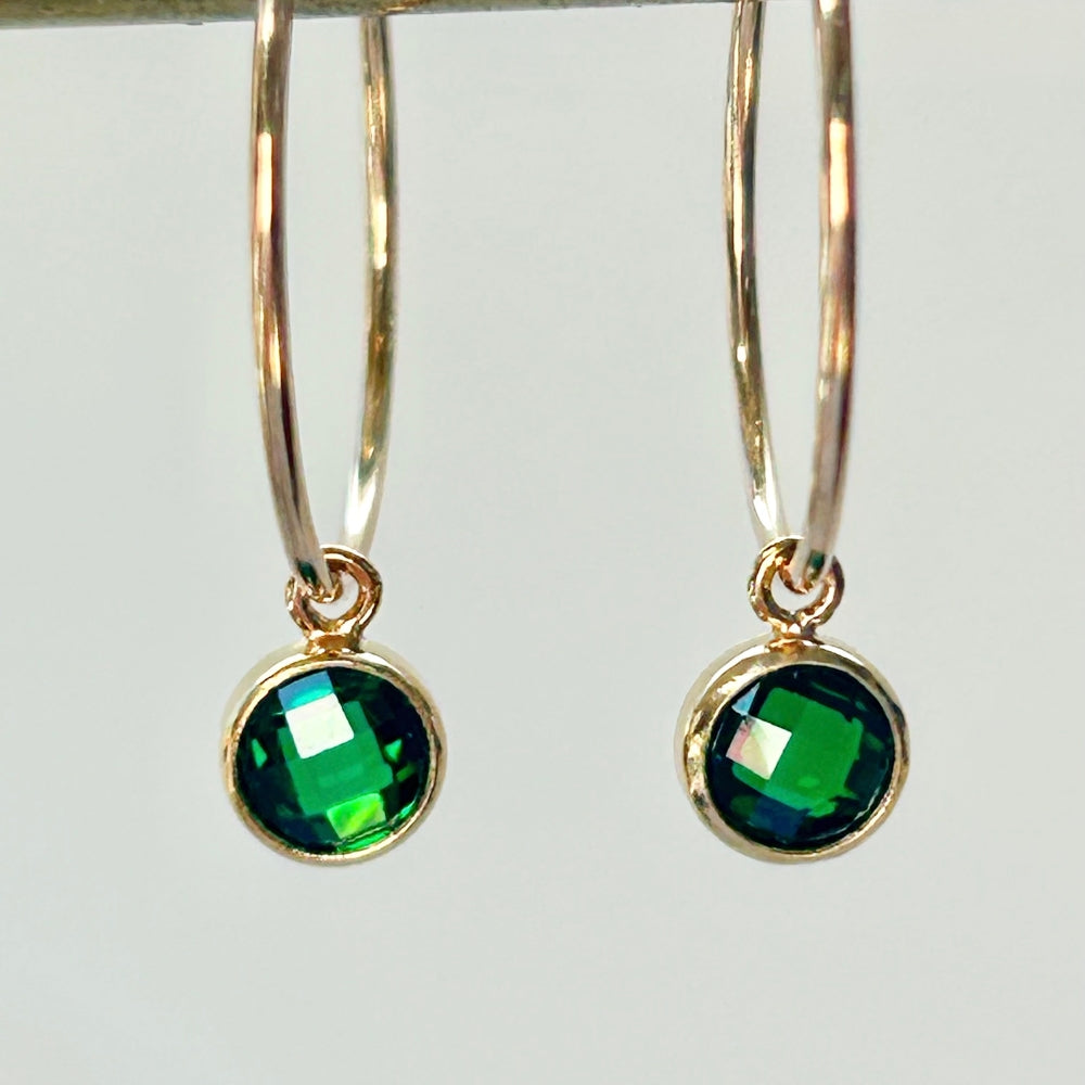 Gold fill hoop earrings with emerald green crystal drops on a white background.