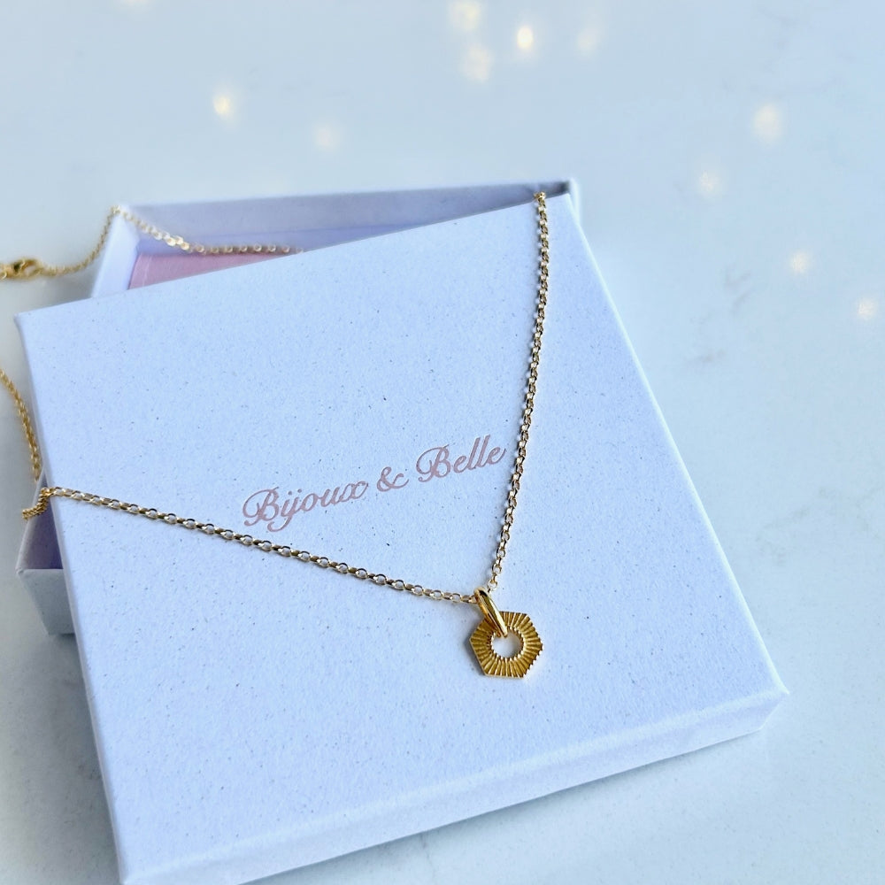 Gold Hexagon Necklace resting on a white jewellery box with "Bijoux & Belle" branding
