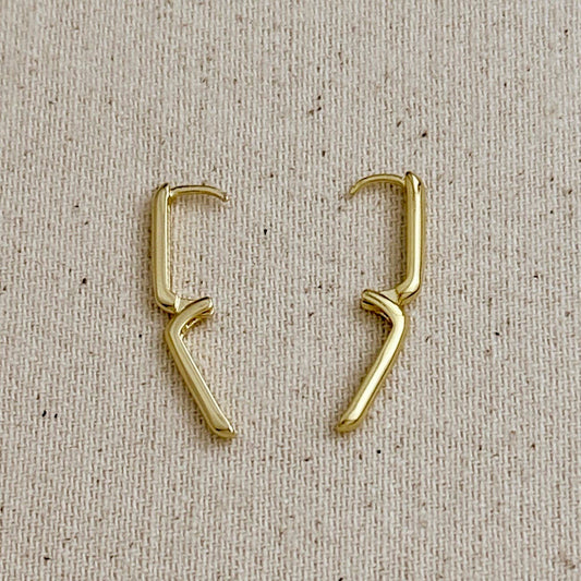 Open gold filled hoop earrings on a beige fabric background.